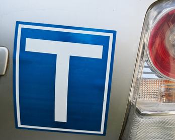 Close-up of a car’s rear with T symbol, representing beginner drivers, learning, growth, and responsibility on the road.