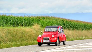 Saint-Blaise, France - August 7, 2014: Retro car Citroen 2CV drives at the interurban road.