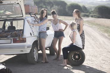 Friends on a road trip changing the car's tyre