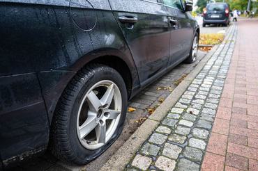 18 September 2025, Bremen: A damaged car with flat tires stands in the Tenever district. The tires of more than 260 cars have been punctured in Bremen over the past three nights. The police have set up a special "tire puncture" squad. Photo: Sina Schuldt/dpa (Photo by Sina Schuldt/picture alliance via Getty Images)