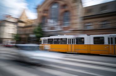 Yellow City Tram Rushes In Motion On A Blurred Budapest Street